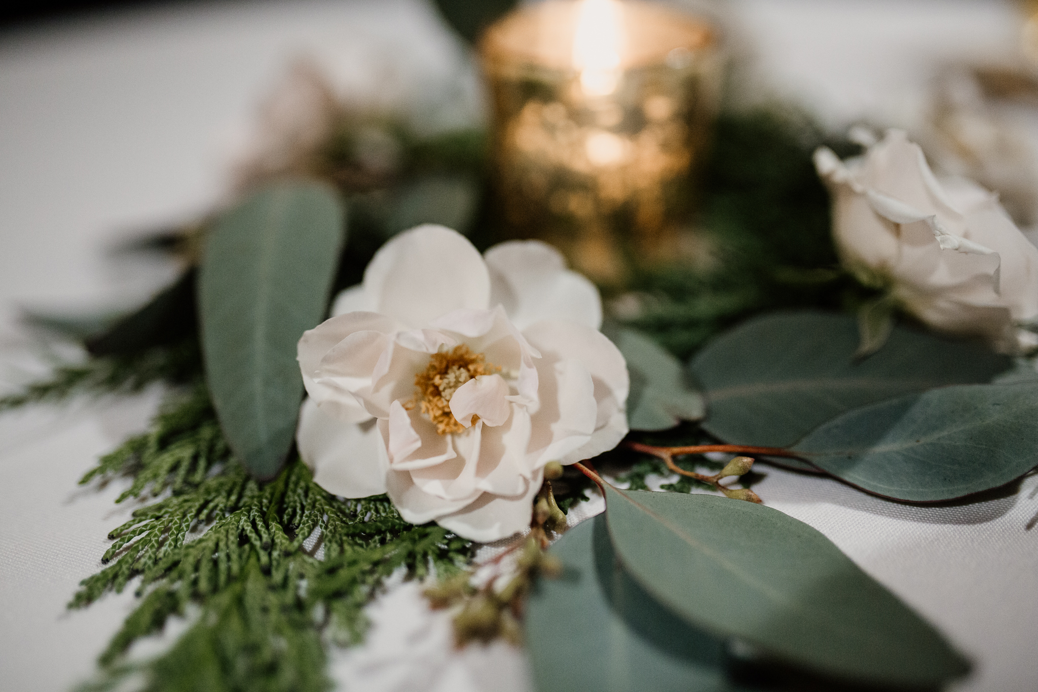 Flower piece table setting by a candle.